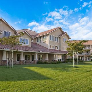 A residential building with a well-maintained lawn and clear blue sky.