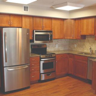A modern kitchen with stainless steel appliances and wooden cabinetry.