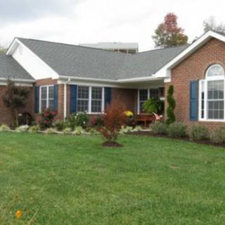 A suburban brick house with a well-maintained lawn.