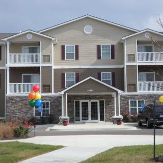A modern apartment building with colorful balloons adorning the entrance.