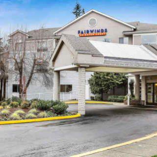 The exterior of a hotel with a covered entrance and landscaped surroundings.