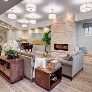 A modern living room featuring a cozy seating area, elegant lighting, and a grand piano.