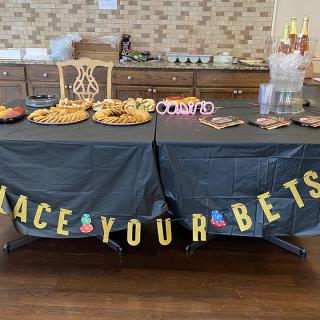 A festively decorated table themed around placing bets, complete with snacks and drinks.