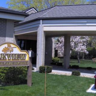A building entrance with a sign and landscaped surroundings.