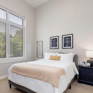 A cozy and modern bedroom featuring a comfortable bed, stylish decor, and ample natural light.