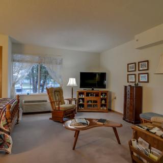 A cozy living room with a TV, coffee table, and comfortable seating.