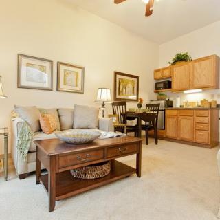 An open-concept living space featuring a cozy seating area with a sofa and coffee table, alongside a compact kitchen and dining area.
