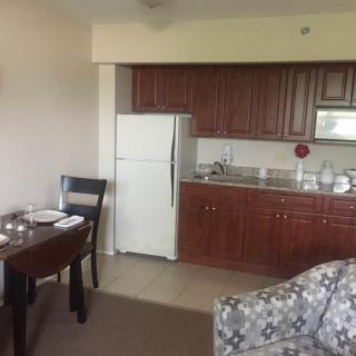 A compact kitchen and dining area with wooden cabinetry and a small dining table.
