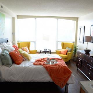 A modern and cozy bedroom with colorful accents and abundant natural light.