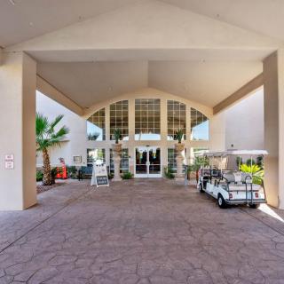 A covered building entrance with a golf cart parked nearby.