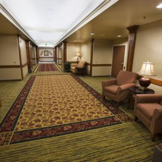 A well-decorated hotel hallway featuring plush seating and elegant carpeting.