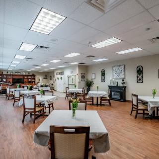A spacious dining room with neatly arranged tables and chairs, featuring elegant decor and warm lighting.