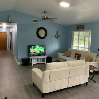 A cozy living room with blue walls, modern furniture, and a television.