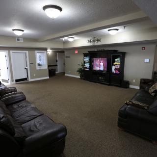 A cozy living room with leather sofas and a large television.