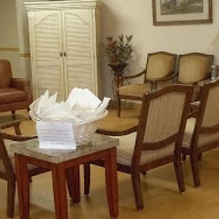 A cozy waiting room featuring comfortable seating and a decorative table.