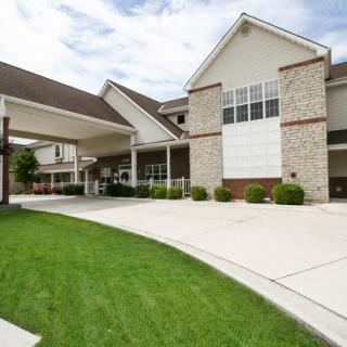 A modern residential building with a driveway and well-maintained lawn.