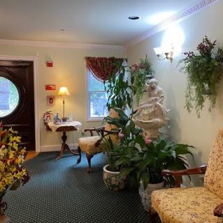 A cozy lobby area adorned with elegant furniture, lush plants, and soft lighting.