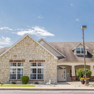 A suburban house with a stone exterior under a clear blue sky.
