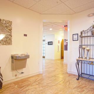 A well-lit office hallway featuring a water fountain and decorative elements.