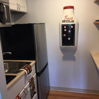 A cozy kitchen featuring modern appliances and a unique milk dispenser.