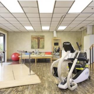 A rehabilitation clinic equipped with various exercise equipment and therapy tools.