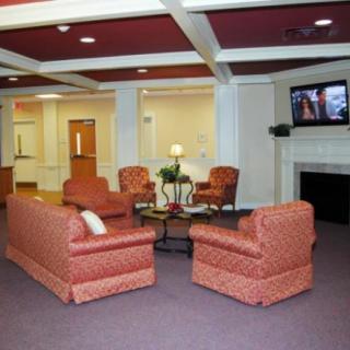 A cozy lobby with comfortable seating, a television, and a fireplace.