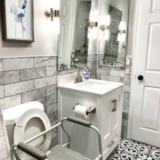 A modern bathroom featuring elegant tiles, a stylish vanity, and functional lighting.