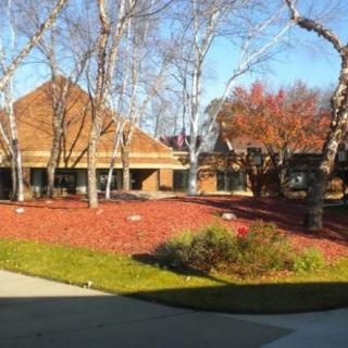 A scenic view of a building surrounded by trees in an autumn landscape.