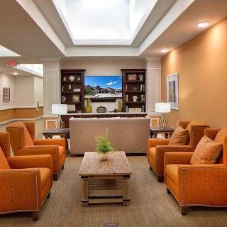 A welcoming lobby area with comfortable orange seating and elegant decor.