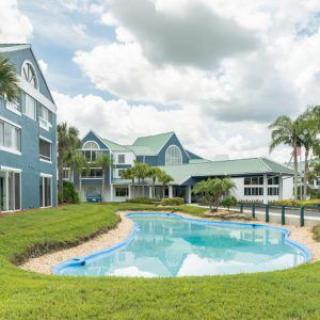 A scenic view of a tropical resort with a swimming pool and lush surroundings.