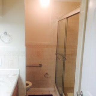 A clean bathroom featuring a glass-enclosed shower and a sink.