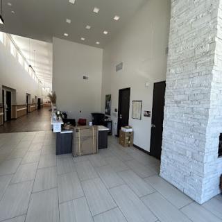 A spacious and modern lobby with a reception area featuring minimalist design and natural light.