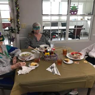 Three people enjoying a meal together at a decorated table.