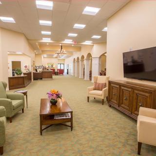 A spacious lobby with comfortable seating and a large television.