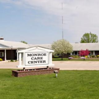 The Monroe Care Center building with a prominent sign in the foreground during daytime.