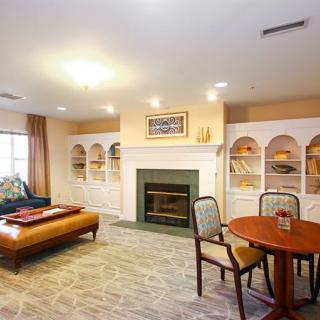 A cozy living room featuring a fireplace surrounded by built-in bookshelves, with comfortable seating and warm lighting.