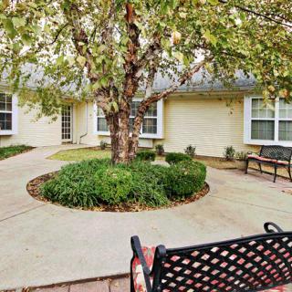 A peaceful courtyard with a central tree surrounded by benches and well-maintained landscaping.