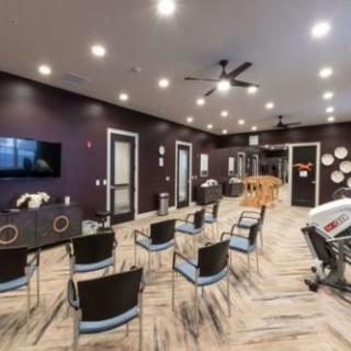 A modern conference room with arranged chairs and a television for presentations.