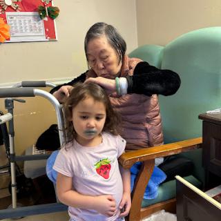 A tender moment between a young child and an elderly woman, showcasing the beauty of family connections.
