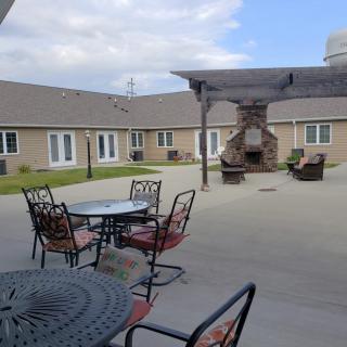 A view of an outdoor courtyard with tables, chairs, and a fireplace.