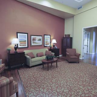 A cozy living room with a sofa, armchairs, and decorative artwork on the wall.
