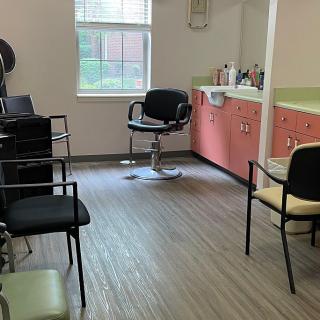 An interior view of a salon with chairs, mirrors, and a window.