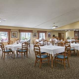 Spacious dining room with neatly arranged tables and chairs.