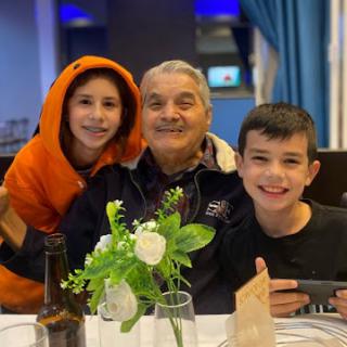 A joyful moment shared between a grandfather and his grandchildren at a restaurant.
