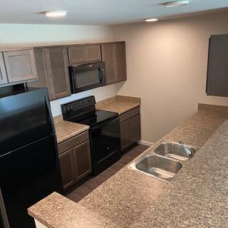 Modern kitchen with appliances and granite countertops.