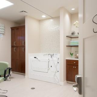 A modern bathroom with a walk-in tub and sleek cabinetry.