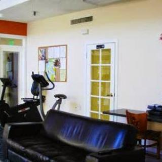A gym with exercise equipment and a sofa in the interior.