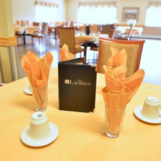 A elegantly set dining table with napkins, coffee cups, and a menu.
