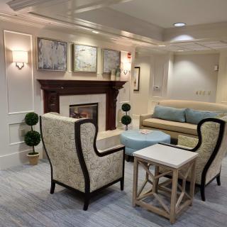 A cozy living room with elegant decor and comfortable seating around a fireplace.