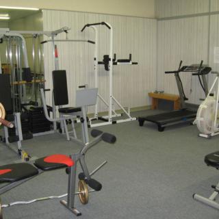 A gym with various exercise equipment including treadmills and weights.